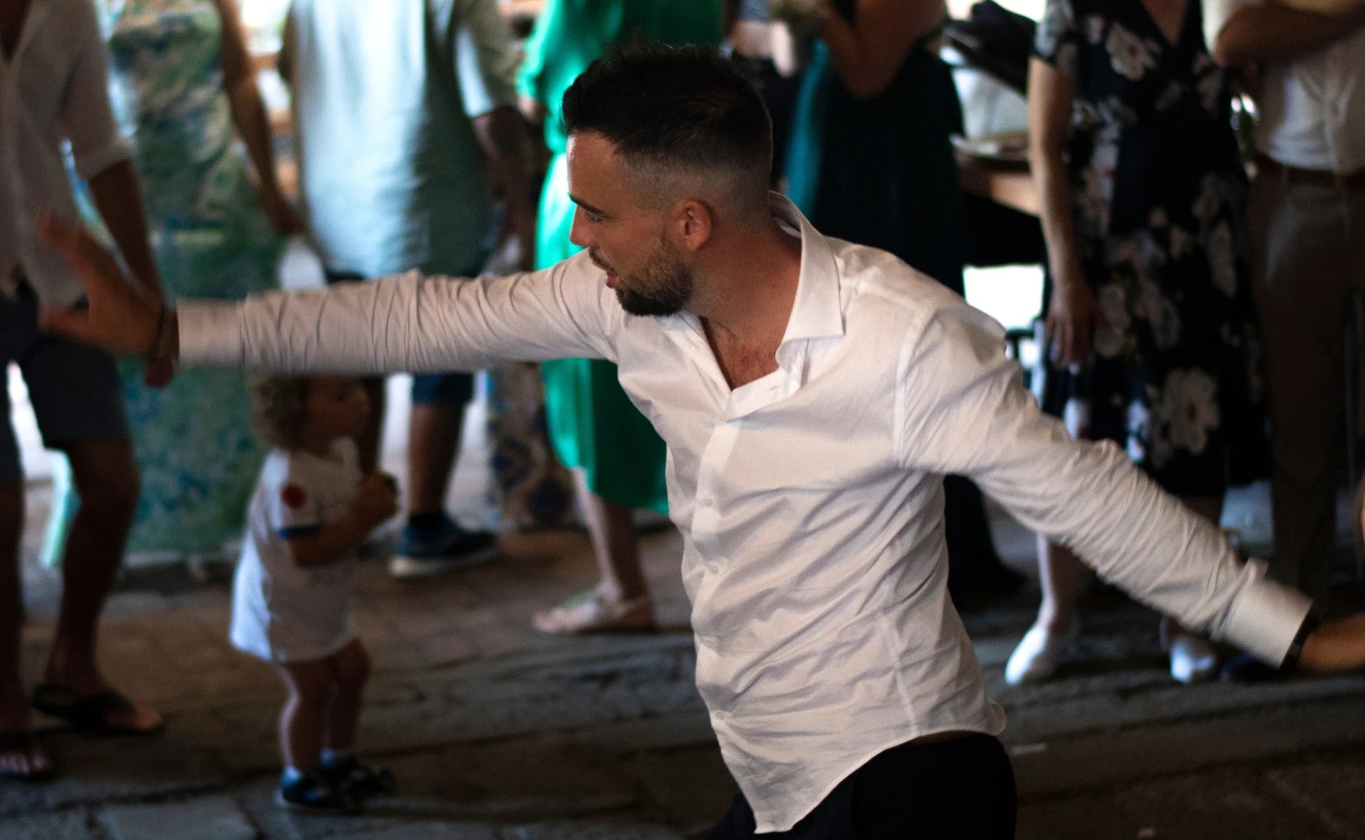 Host v bílé košili energicky tancuje na plném parketu během akce, kde hraje DJ na party a firemní večírek Petr Divíšek.